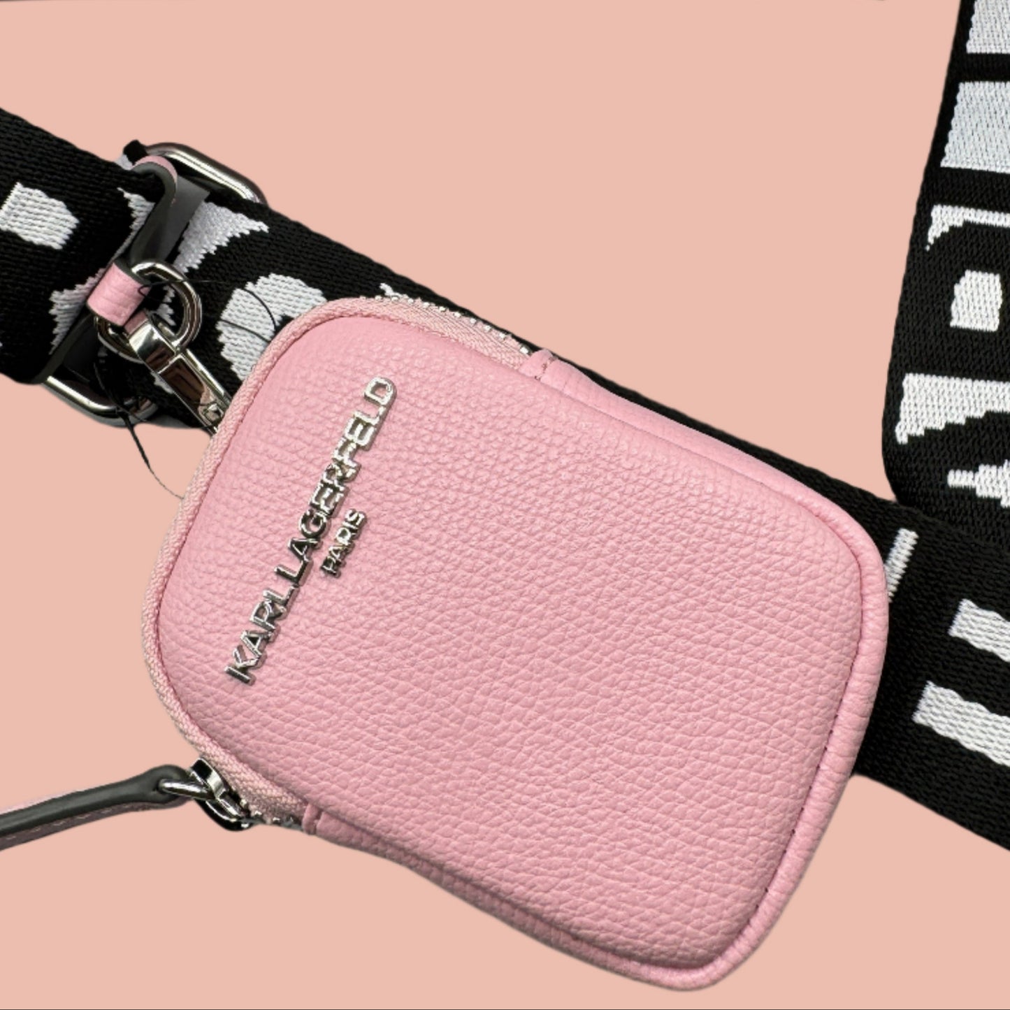 Pink pouch with decorative studs and a strap on a gray background