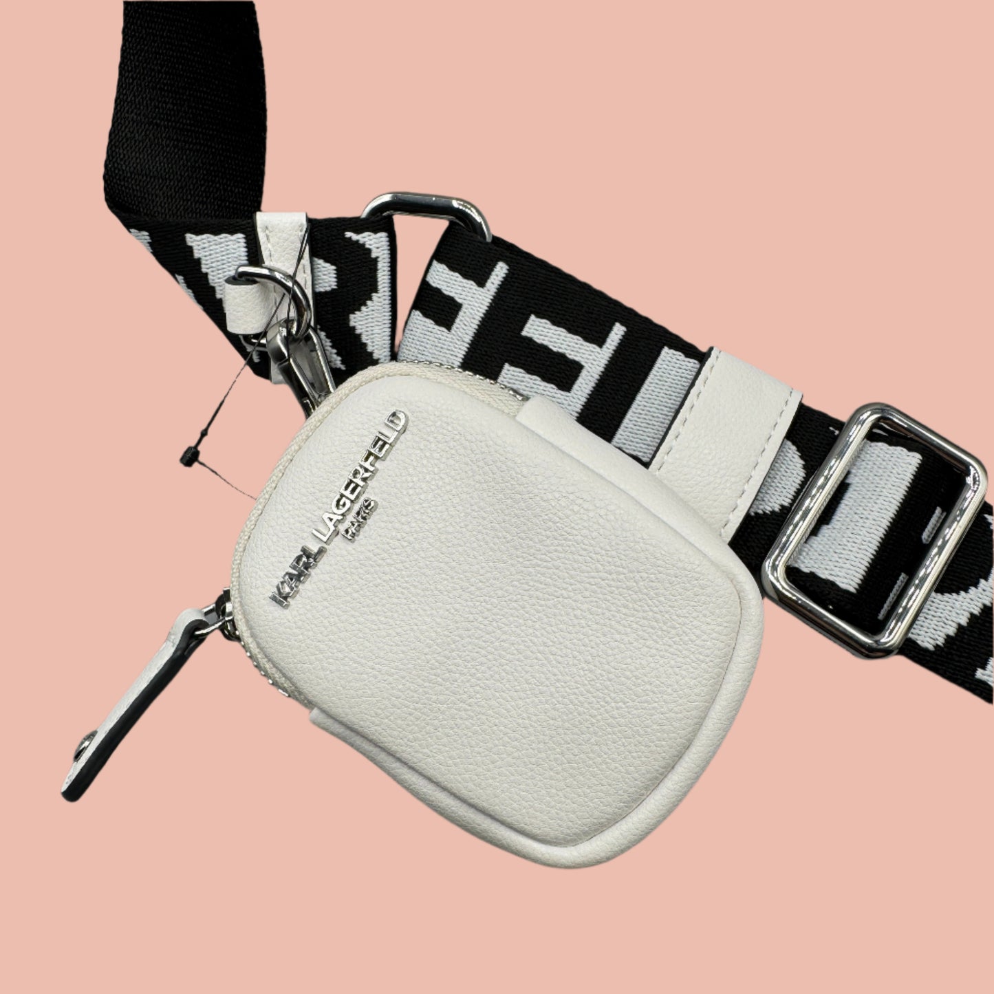 White pouch with black and white patterned strap on a gray surface karl lagerfeld