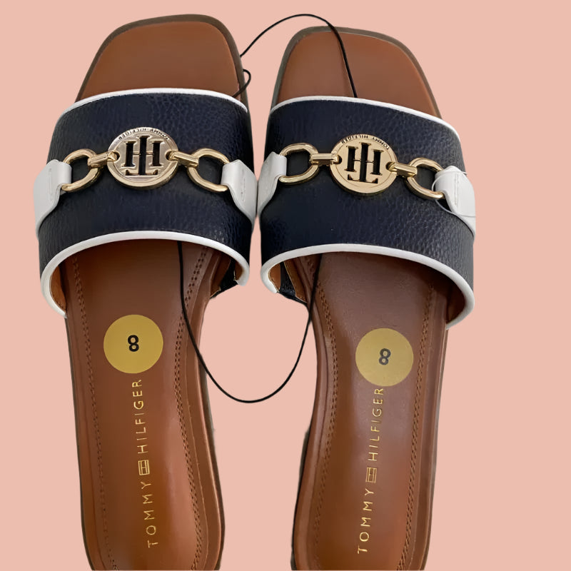 Pair of Tommy Hilfiger sandals with chain detail on a white background