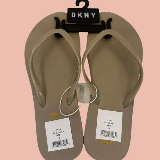 Pair of beige flip-flops with DKNY branding on a white background
